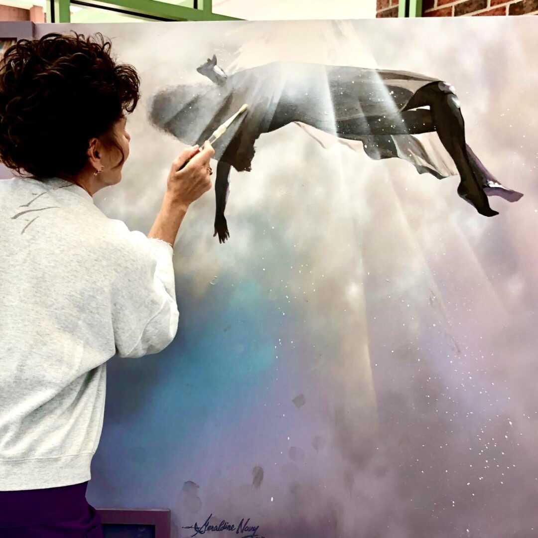 A woman painting a picture of a person falling.