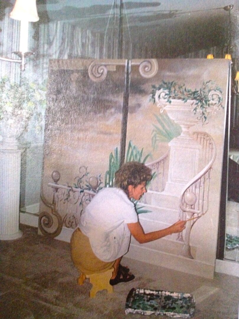 A man is painting on the wall of a room.